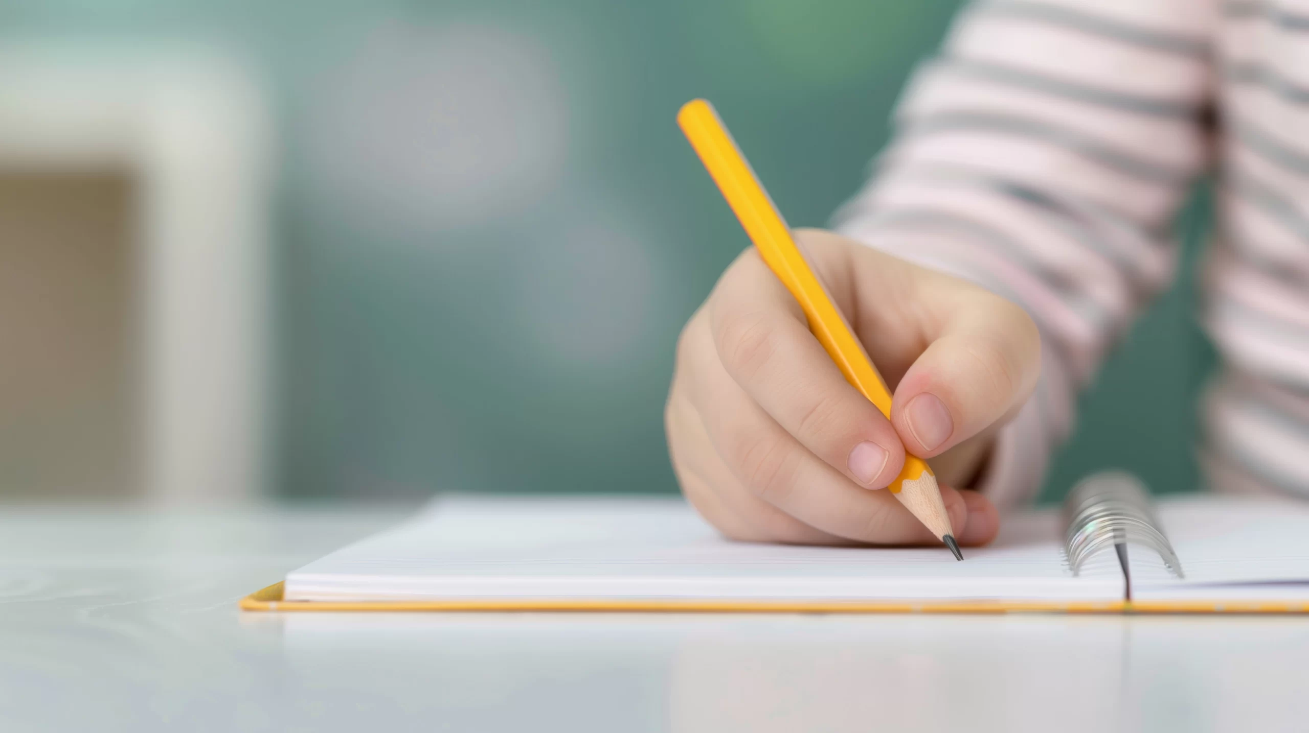vecteezy_close-up-of-child-s-hands-writing-with-pencil-on-notebook-in_49626034.jpeg